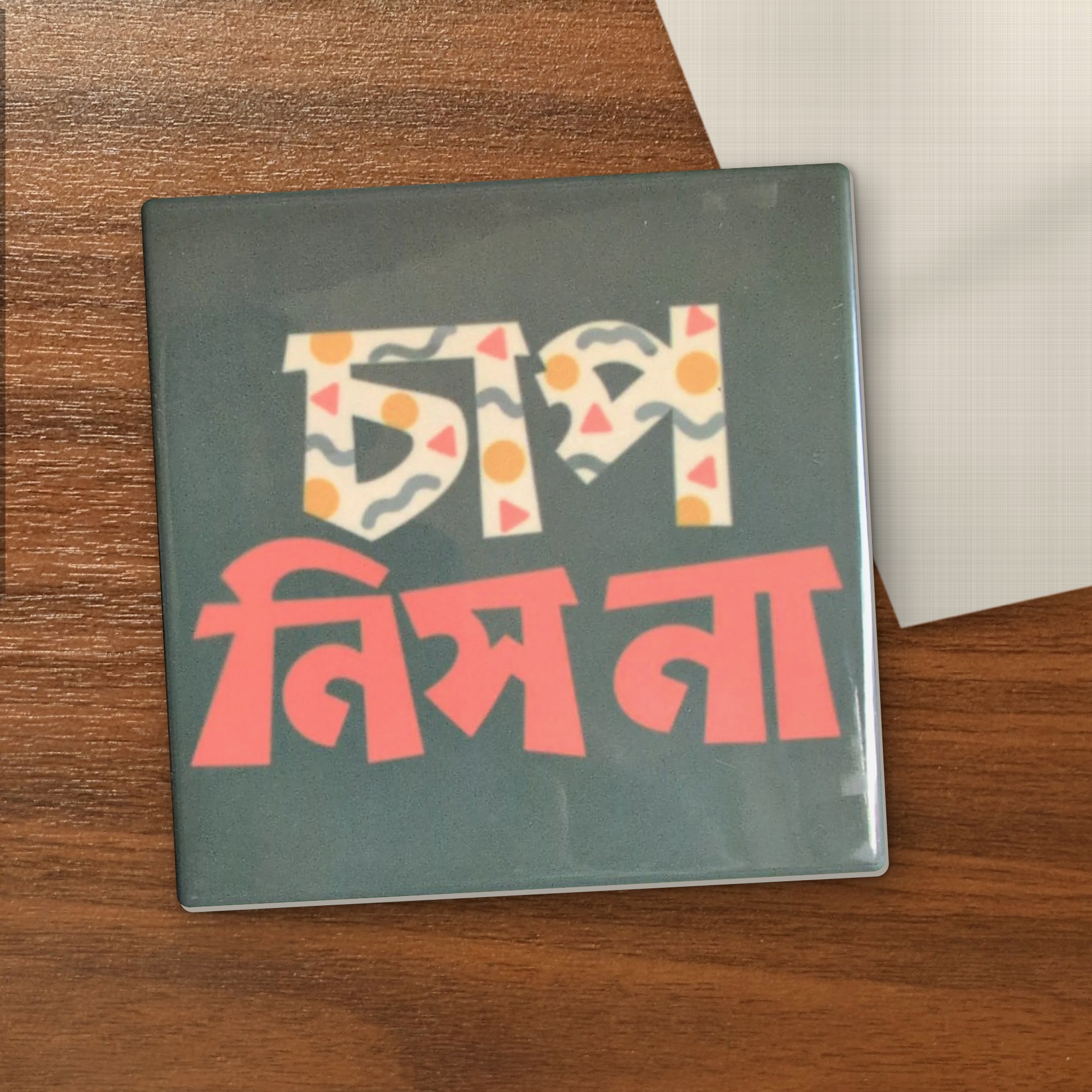 Chap Nish Naa coaster on a wooden table
