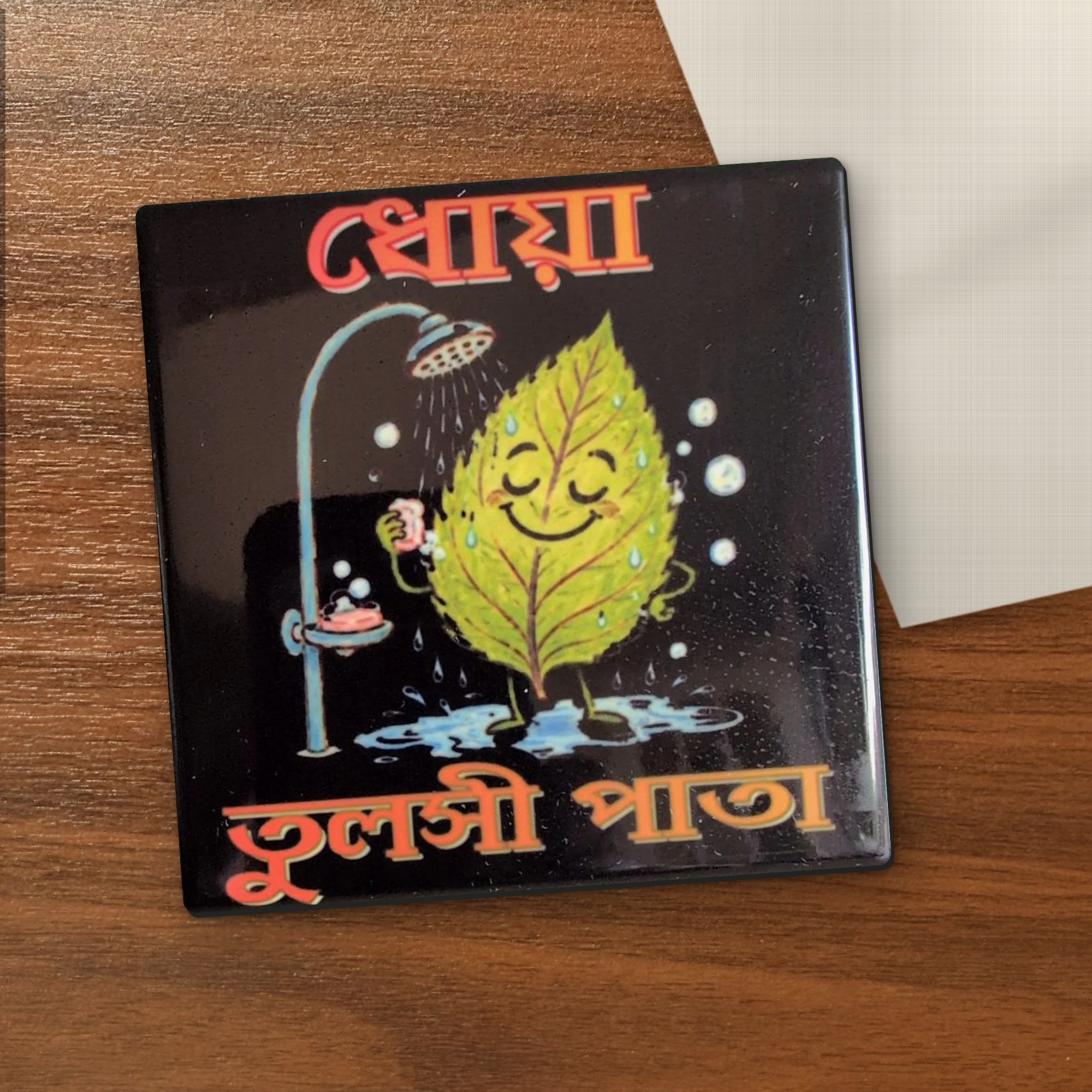 Dhoa Tulsi Pata coaster on a wooden table